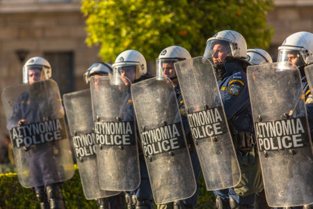 ATHENS, GREECE - APR 16, 2015: Riot police with their shield, take cover during a rally in front of the Athens University, which is under occupation by protesters leftist and anarchist groups.のeditorial素材