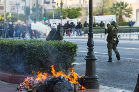 ATHENS, GREECE - APR 16, 2015: Riot police with their shield, take cover during a rally in front of...