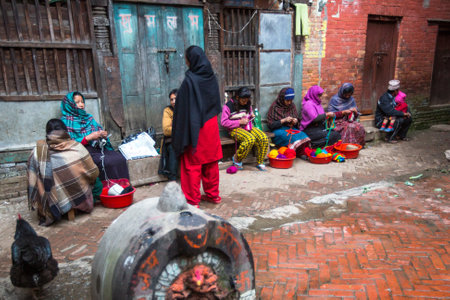 BHAKTAPUR, NEPAL - CIRCA DEC, 2013: Unidentified local people sit in the street. The caste system is still intact today but the rules are not as rigid as they were in the past.のeditorial素材