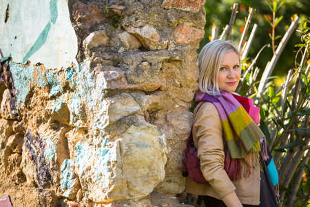 Young fashion woman near old stone walls in the Park.の写真素材