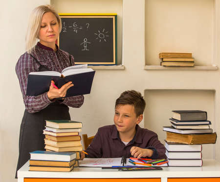 Elementary school student doing homework with the help of a tutor.の写真素材