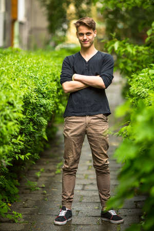 Full length portrait of happy handsome young man summer outdoors.の写真素材