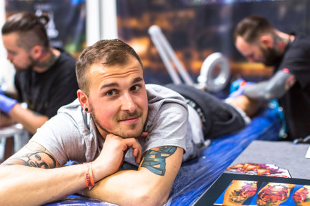 KRAKOW, POLAND - JUNE 6, 2015: People make a tattoos at the 10-th International Tattoo Convention in the Congress-EXPO Center. This year anniversary TattooFest is tattoo Studio with an area of 2000m2.のeditorial素材