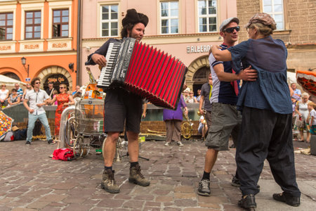KRAKOW, POLAND - JUL 12, 2015: Participants at the annually (July 9-12) 28th International Festival of Street Theatres - Orchestre International du Vetex (Belgium/France) in the Main Square of Krakow.のeditorial素材