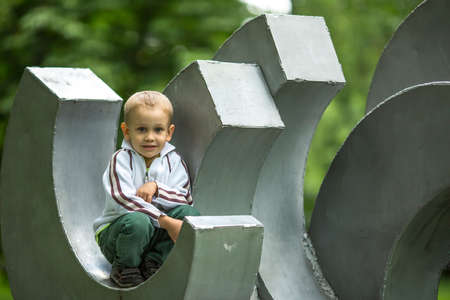 Little fun boy is sitting in the children's park playground.の写真素材