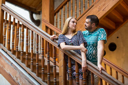 Couple in love standing on the old wooden staircase.の写真素材