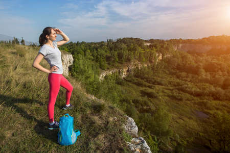 Young sport woman traveler on the top of mountain.