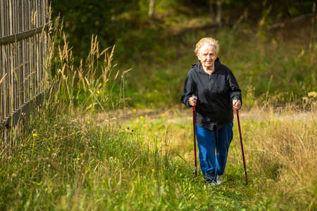 Mature woman engaged in Nordic walking outside the city.の写真素材