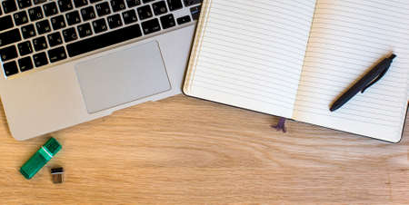 Laptop and Notepad with pen top view on the background of wood texture.の写真素材