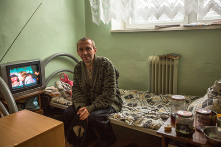 VINNITSY, RUSSIA - NOV 30, 2015: Disabled man in rehabilitation department in Center of social services for pensioners and the disabled. 2015 - the year of the older generation in Leningrad region.のeditorial素材