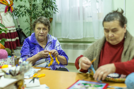 VINNITSY, RUSSIA - NOV 30, 2015: Elderly people during occupational therapy for eldery and disabled in rehabilitation department in Center of social services for pensioners and the disabled.のeditorial素材