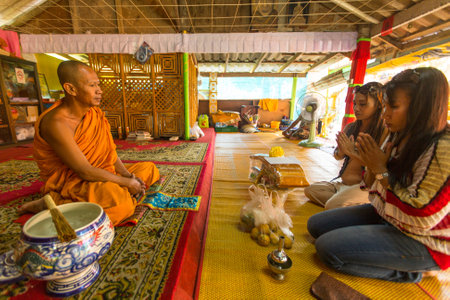KOH CHANG - THAILAND - DEC 29, 2015: Unidentified local women give offerings to monks in the Wat Khlong Prao monastery. Ko Chang one of the largest Islands of Thailand, located of 310 km from Bangkok.のeditorial素材