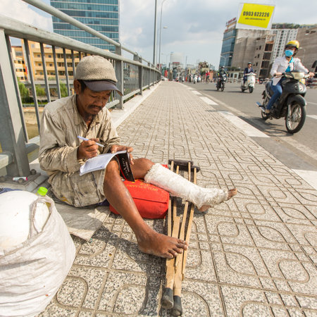 HO CHI MINH, VIETNAM - JAN 14, 2016: Local poor vietnamese man sitting on the street. Located in the South of Vietnam, Ho Chi Minh City is the country's largest city, population 8 million.のeditorial素材