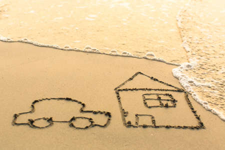 House and a Car drawing on the beach sand with the soft wave.の写真素材