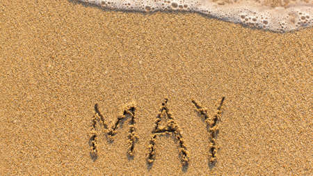 Inscription MAY on a gentle beach sand with the soft wave (months of the year series)