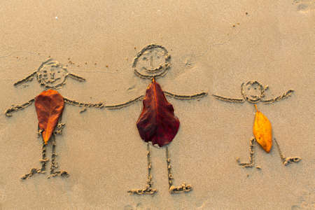 Family, three people drawn on the beach sand.の写真素材