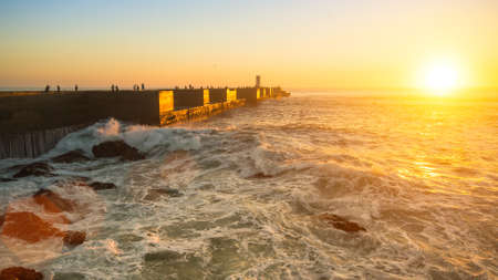 Ocean coast and stone pier during stunning sunset.の写真素材
