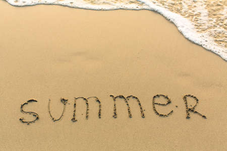 Summer - inscription on sand beach with the soft wave.