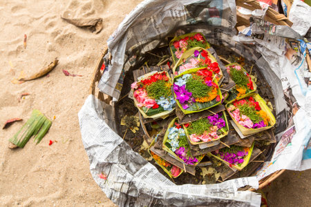 SANUR, BALI - MAR 18, 2016: Donations sacrifice during Melasti Ritual. Ceremony is held on the edge of the beach with the aim to purify oneself of all the bad things in the past and throw it to ocean.のeditorial素材
