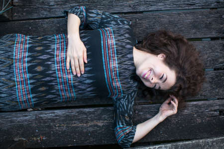 Beautiful asian woman lying on wooden floor.の写真素材