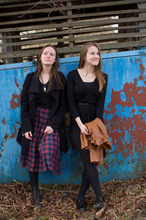 Young cute teenagers girls pensively cost about textured wall.の写真素材