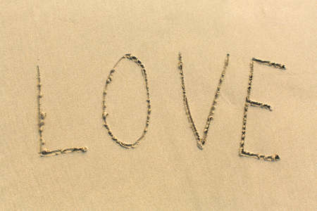 LOVE - word drawn on the sand beach.