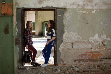 Two teen girls standing in the aisle in an abandoned building.の写真素材