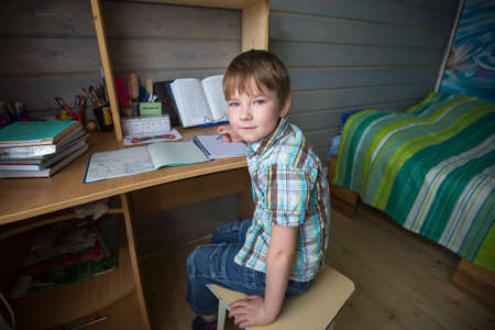 Little boy sitting at home doing homework.