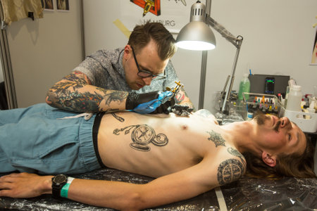 KRAKOW, POLAND - JUNE 11, 2016: Unidentified festival participant make a tattoos at the 11-th International Tattoo Convention in the Congress-EXPO Center of Krakow.のeditorial素材
