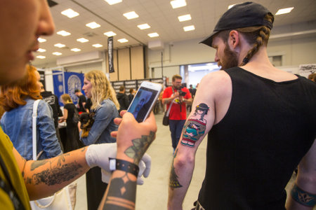 KRAKOW, POLAND - JUNE 11, 2016: Unidentified festival participant make a tattoos at the 11-th International Tattoo Convention in the Congress-EXPO Center of Krakow.のeditorial素材