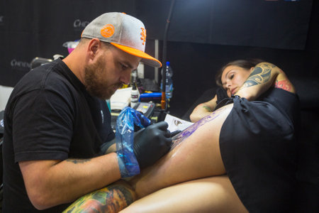 KRAKOW, POLAND - JUNE 11, 2016: Unidentified festival participant make a tattoos at the 11-th International Tattoo Convention in the Congress-EXPO Center of Krakow.のeditorial素材