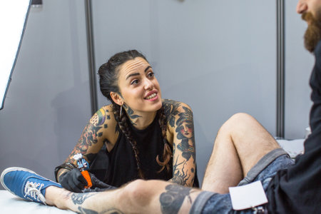 KRAKOW, POLAND - JUNE 12, 2016: Unidentified festival participant make a tattoos at the 11-th International Tattoo Convention in the Congress-EXPO Center of Krakow.のeditorial素材