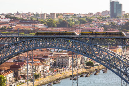 PORTO, PORTUGAL - JUL 12, 2016: Train of Porto Metro on Dom Luis iron Bridge in Old Town. The network has 6 lines and reaches seven municipalities within the metropolitan Porto area.のeditorial素材