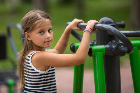 Portrait of little girl doing warm-up on the Playground.の写真素材