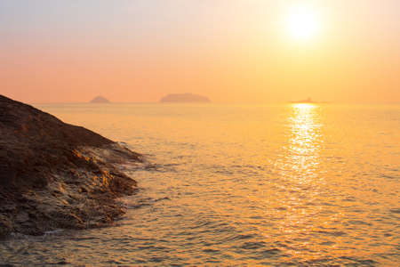 Rocky sea shore against the setting sun.の写真素材