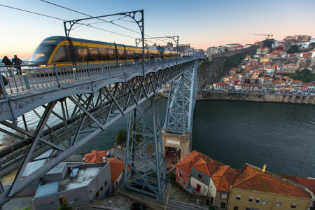 PORTO, PORTUGAL - DEC 28, 2016: Train of Porto Metro on Dom Luis iron Bridge in Old Town. The network has 6 lines and reaches seven municipalities within the metropolitan Porto area.のeditorial素材