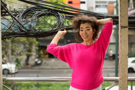 Young Asian woman urban portrait among the wires.