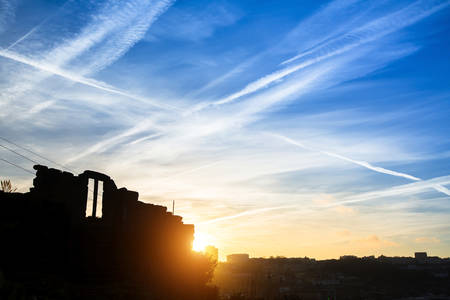 Destroyed an abandoned building on the blue sky background during sunset.