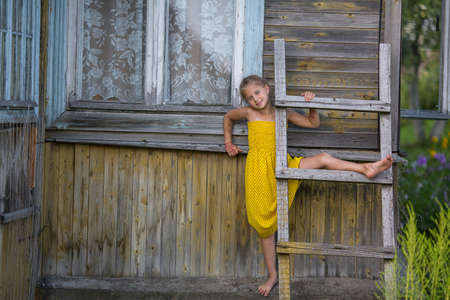 Funny little girl playing near village houses.の写真素材