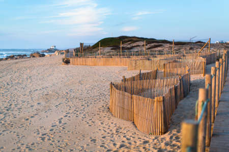Wooden fence on sand dunes at Miramar beach on the Atlantic coast of Portugal.の写真素材