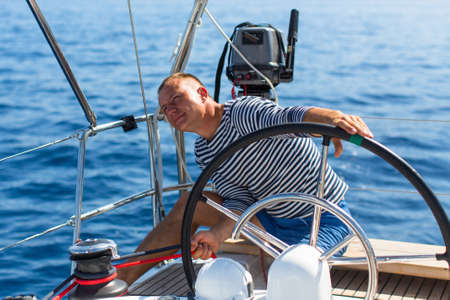 Man manages a sailing yacht during a race at sea.の写真素材