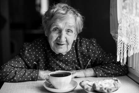 Elderly woman drinking tea. Black and white portrait.の写真素材