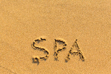 Spa - inscription by hand on a sandy golden sea beach.の写真素材