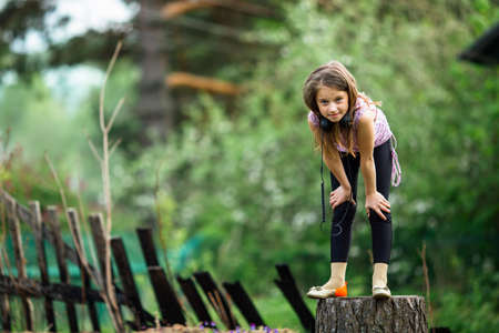 Cute little girl in headphones enjoying music in nature.の写真素材