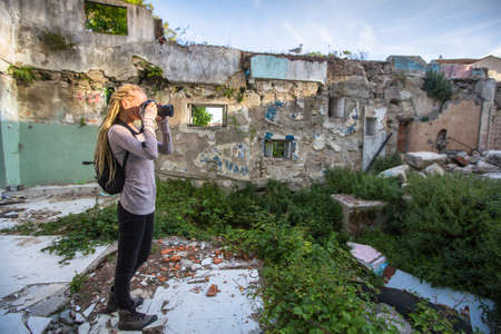 Young woman taking pictures of ruins abandoned buildings.の写真素材