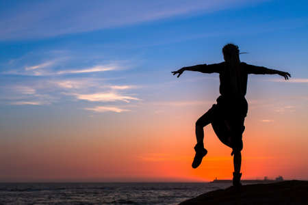 Silhouette woman activity on the sea beach at amazing sunset.の写真素材