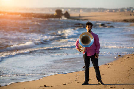 Man musician playing the Tuba on the sea coast.の写真素材