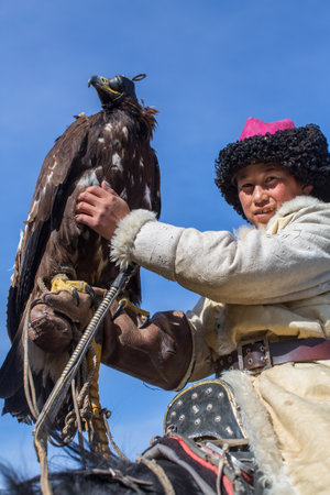 BAYAN-ULGII, MONGOLIA - SEP 30, 2017: Kazakh Eagle Hunter traditional clothing, while hunting to the...