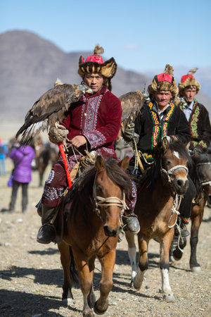 OLGIY, MONGOLIA - SEP 30, 2017: Kazakh Golden Eagle Hunter at traditional clothing, with a golden...