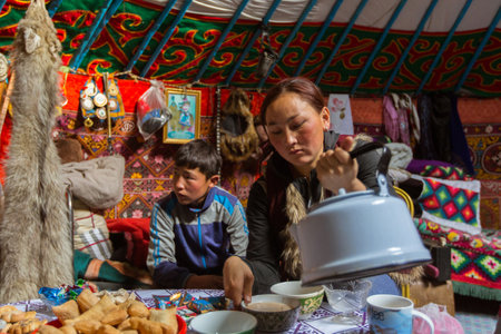 BAYAN-OLGII, MONGOLIA - SEP 28, 2017: Kazakhs family of hunters with hunting golden eagles inside their the mongolian Yurts. In Bayan-Olgii Province is populated to 88,7% by Kazakhs.のeditorial素材